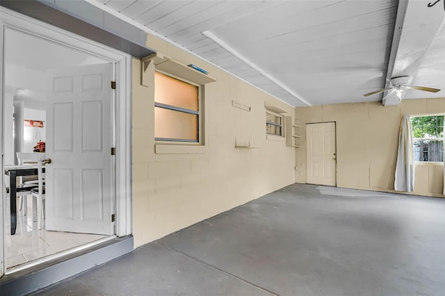 garage with ceiling fan and concrete block wall