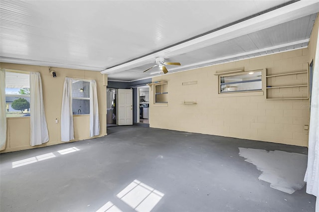 garage with ceiling fan and concrete block wall