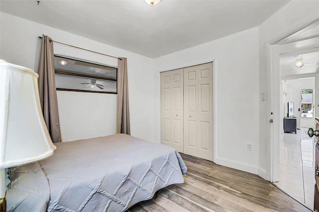 bedroom featuring a closet, baseboards, and wood finished floors