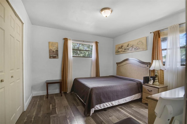 bedroom featuring baseboards and dark wood finished floors