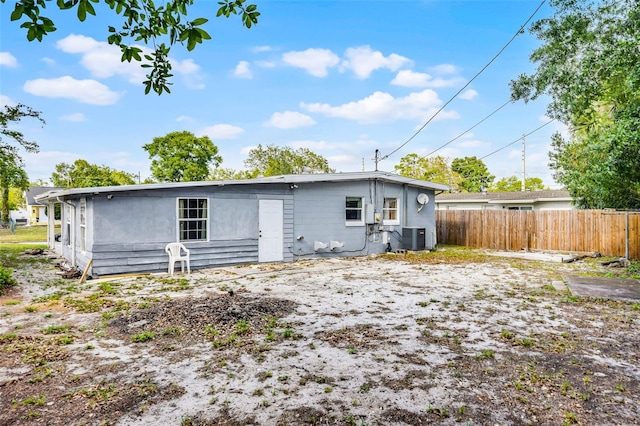 back of house with central AC and fence