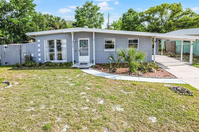 ranch-style home featuring a carport, driveway, fence, and a front lawn