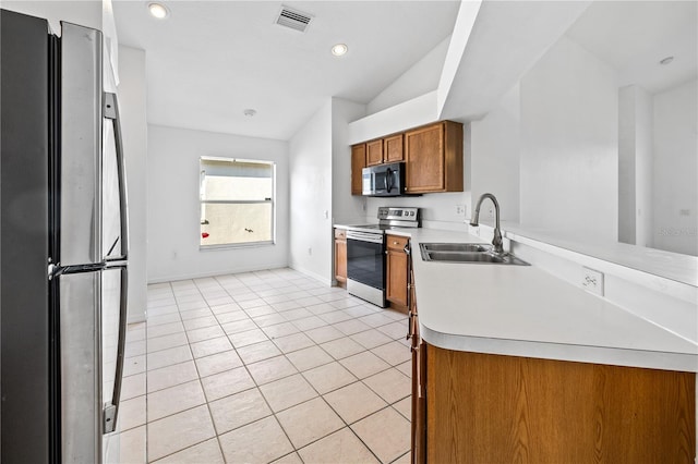 12511 Lake Vista Dr, Gibsonton, FL 33534 - kitchen featuring appliances with stainless steel finishes, light countertops, a sink, brown cabinets, and baseboards
