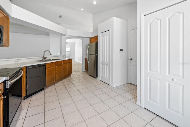 12511 Lake Vista Dr, Gibsonton, FL 33534 - kitchen featuring arched walkways, brown cabinets, a sink, and stainless steel appliances