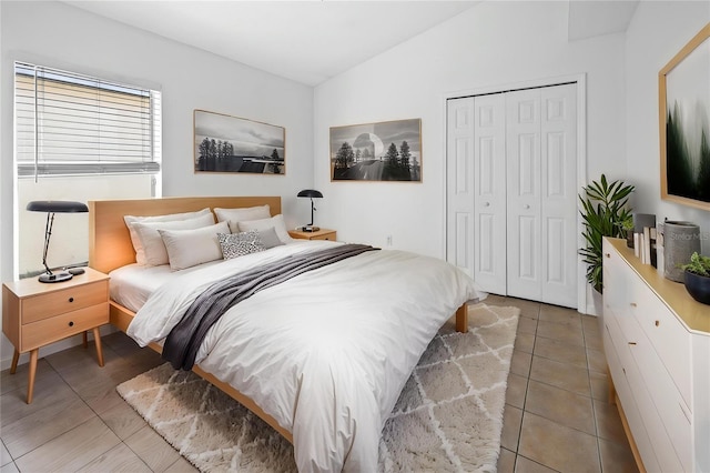 12511 Lake Vista Dr, Gibsonton, FL 33534 - bedroom with a closet, light tile patterned floors, and vaulted ceiling