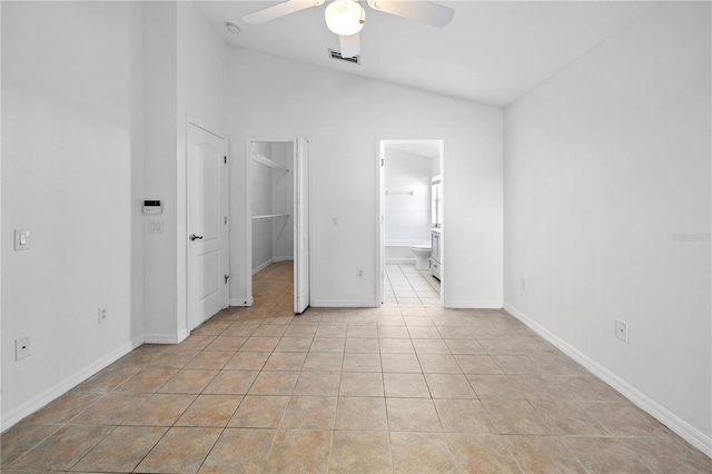 12511 Lake Vista Dr, Gibsonton, FL 33534 - unfurnished bedroom featuring ensuite bath, light tile patterned flooring, a walk in closet, visible vents, and lofted ceiling