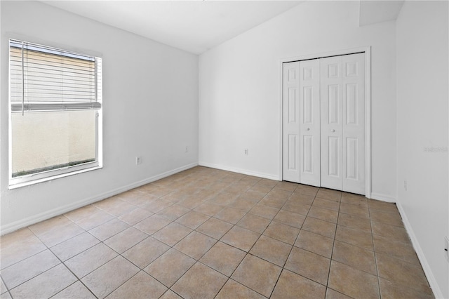12511 Lake Vista Dr, Gibsonton, FL 33534 - unfurnished bedroom with tile patterned flooring, a closet, and baseboards