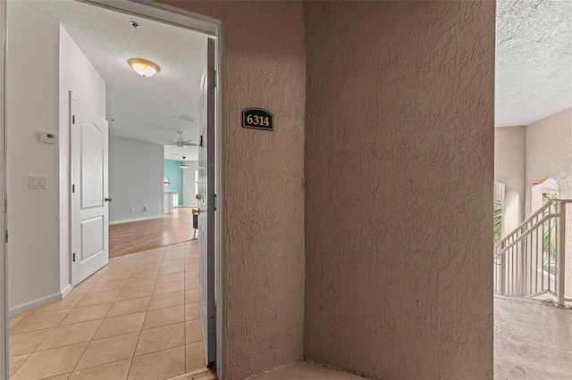 4897 Cypress Woods Dr Unit 6314, Orlando, FL 32811 - hallway featuring baseboards, light tile patterned flooring, and a textured ceiling