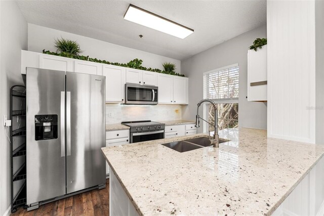 4897 Cypress Woods Dr Unit 6314, Orlando, FL 32811 - kitchen with appliances with stainless steel finishes, white cabinets, light stone countertops, decorative backsplash, and a sink