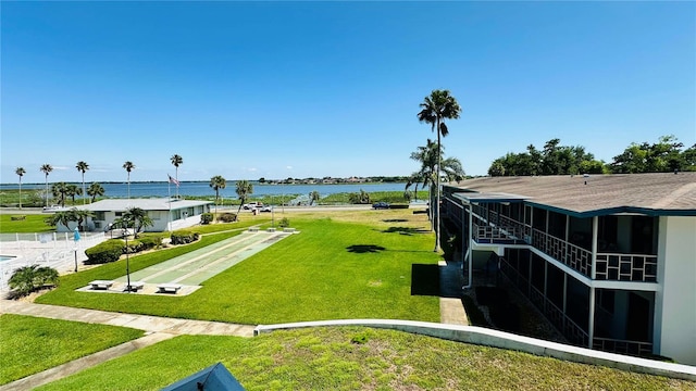 exterior space with a water view and a lawn