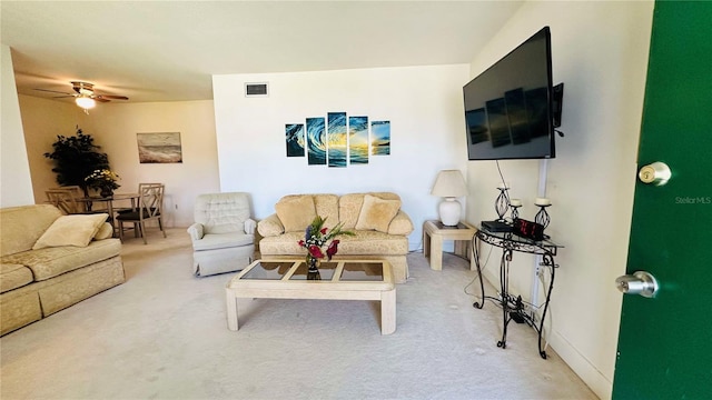 carpeted living area with visible vents, baseboards, and a ceiling fan