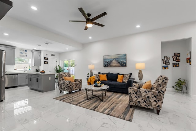 living area featuring marble finish floor, a ceiling fan, and recessed lighting