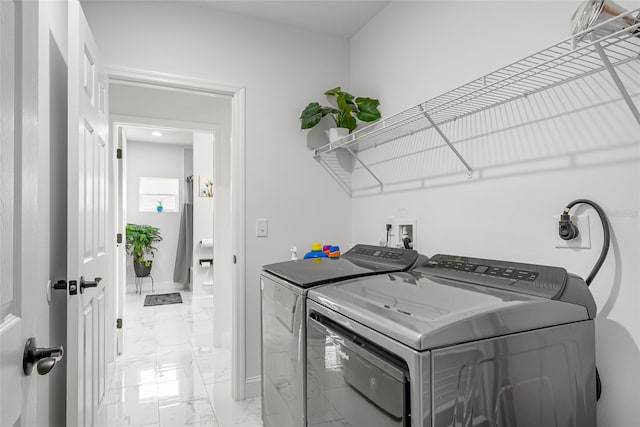 laundry area with independent washer and dryer, laundry area, marble finish floor, and baseboards