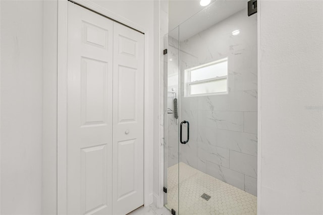 full bathroom with a closet and a marble finish shower