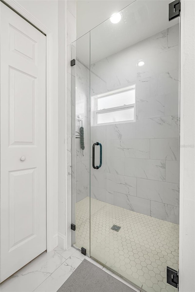 bathroom with a marble finish shower and marble finish floor