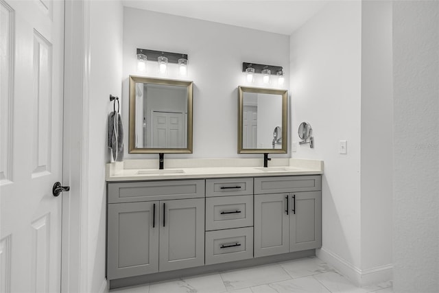 bathroom with baseboards, double vanity, marble finish floor, and a sink