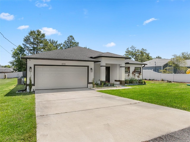 prairie-style home with stucco siding, fence, an attached garage, and a front lawn