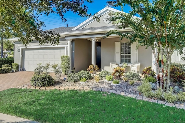 view of front of property with a garage, stucco siding, and decorative driveway