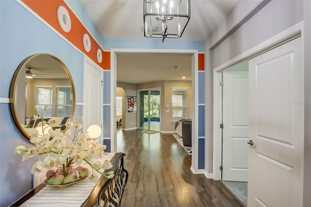 corridor with a healthy amount of sunlight, an inviting chandelier, and baseboards