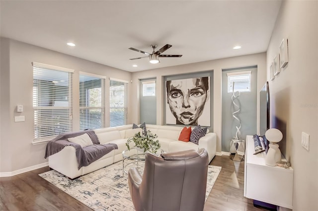 living area featuring a wealth of natural light, baseboards, wood finished floors, and ceiling fan
