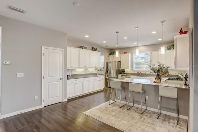 kitchen featuring white cabinets, decorative backsplash, visible vents, and stainless steel refrigerator with ice dispenser