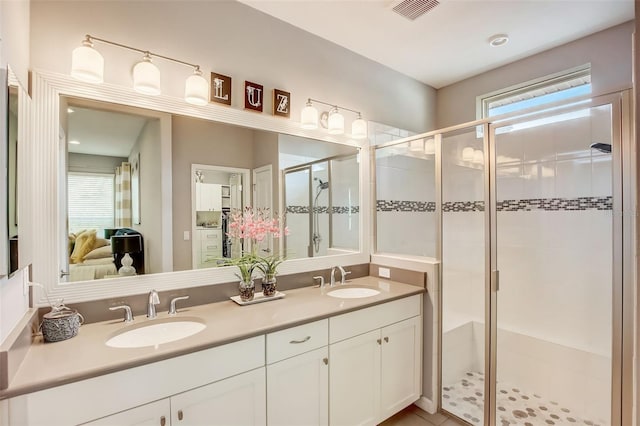 bathroom featuring a sink, visible vents, double vanity, and a stall shower