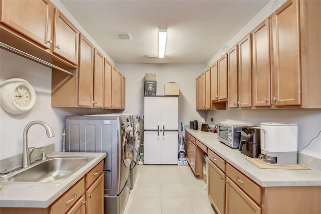 laundry area featuring a textured ceiling, visible vents, independent washer and dryer, cabinet space, and a sink