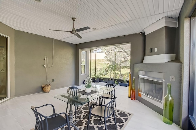 dining room featuring a large fireplace and a ceiling fan