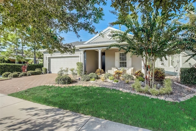 view of front facade featuring a garage, stucco siding, a front yard, and decorative driveway