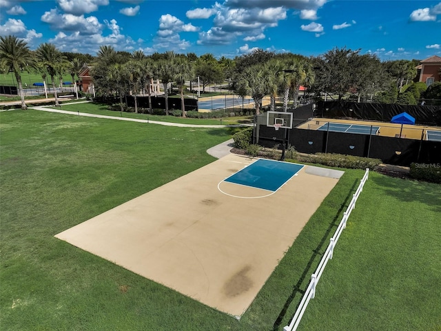 view of sport court featuring fence, community basketball court, and a lawn