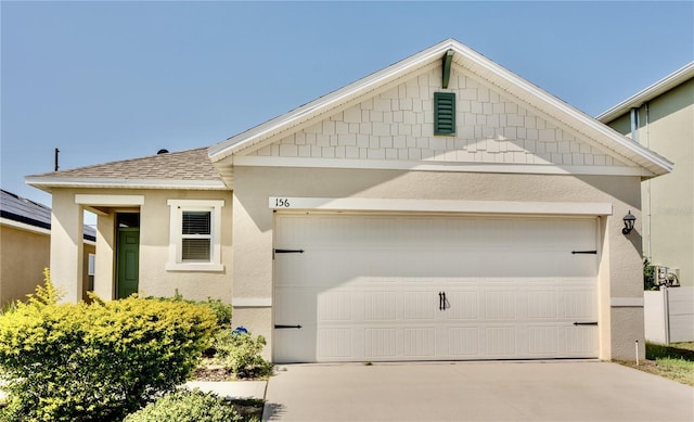 156 Eagleview Loop, Davenport, FL 33837 - view of front of house with concrete driveway, stucco siding, an attached garage, and roof with shingles