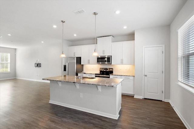 6165 Juneberry Way, Winter Garden, FL 34787 - kitchen featuring an island with sink, dark wood finished floors, visible vents, appliances with stainless steel finishes, and a sink