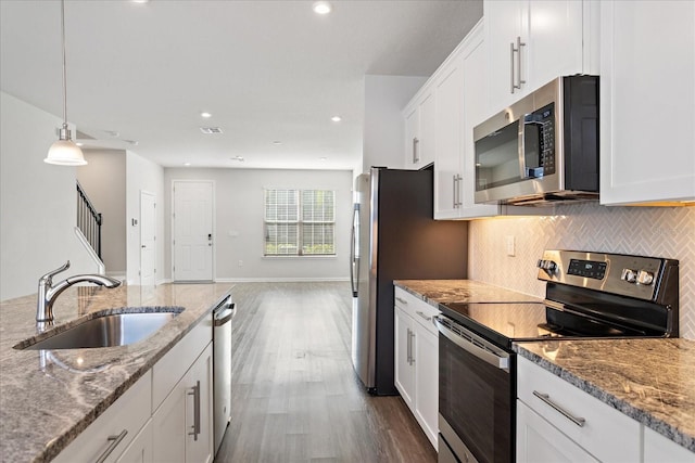 6165 Juneberry Way, Winter Garden, FL 34787 - kitchen featuring tasteful backsplash, dark wood-style flooring, white cabinets, stainless steel appliances, and a sink