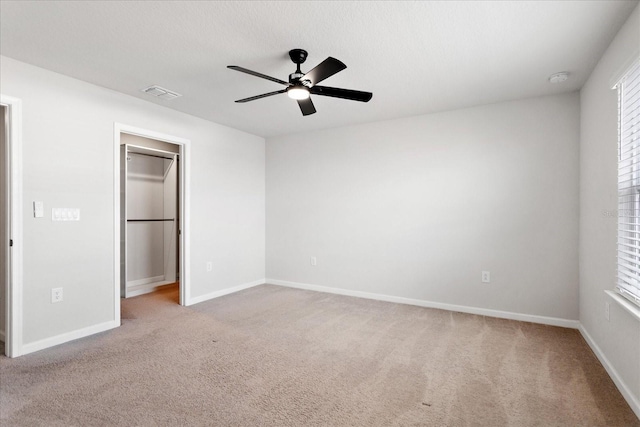 6165 Juneberry Way, Winter Garden, FL 34787 - unfurnished bedroom with ceiling fan, carpet, visible vents, a walk in closet, and baseboards