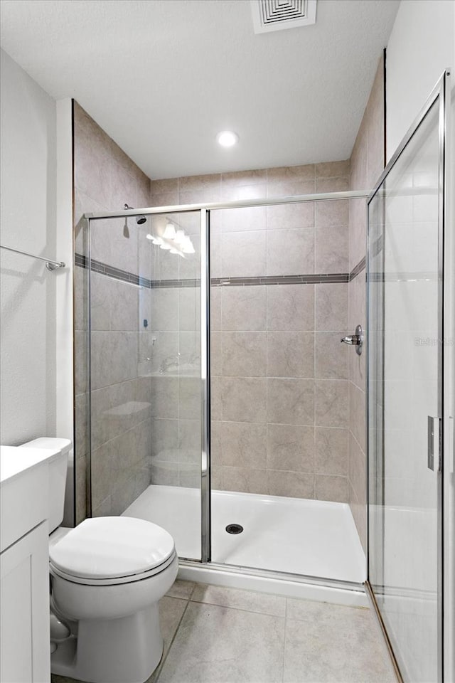6165 Juneberry Way, Winter Garden, FL 34787 - full bath featuring tile patterned flooring, visible vents, a stall shower, and toilet