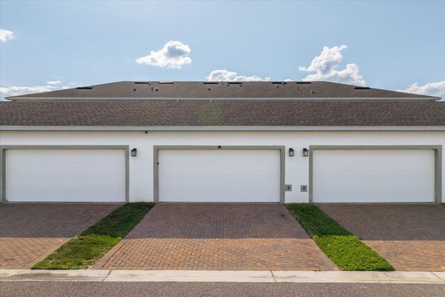6165 Juneberry Way, Winter Garden, FL 34787 - exterior space with roof with shingles, community garages, and stucco siding
