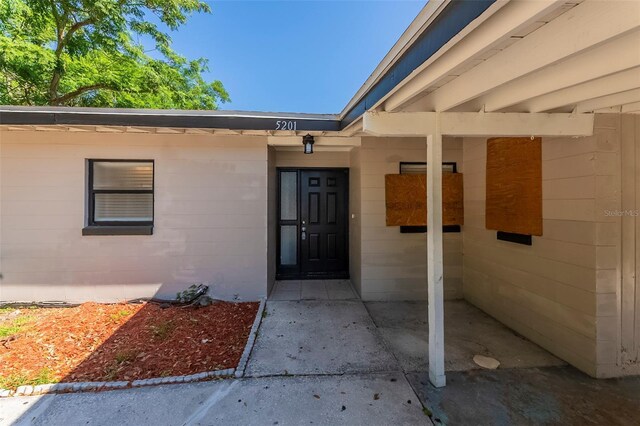 doorway to property featuring concrete block siding
