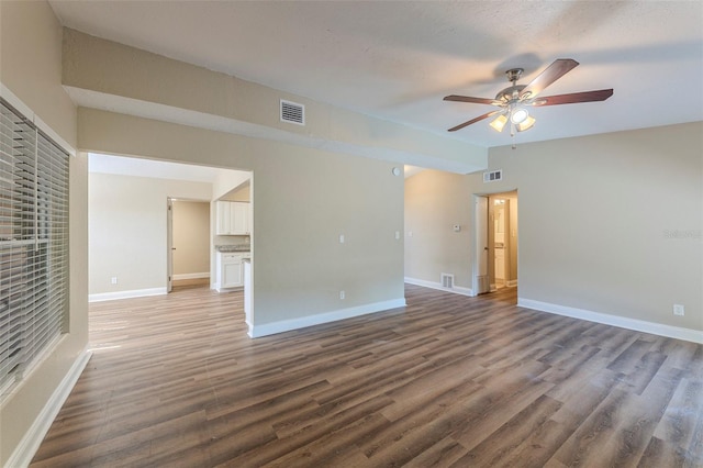 empty room with visible vents, ceiling fan, wood finished floors, and baseboards