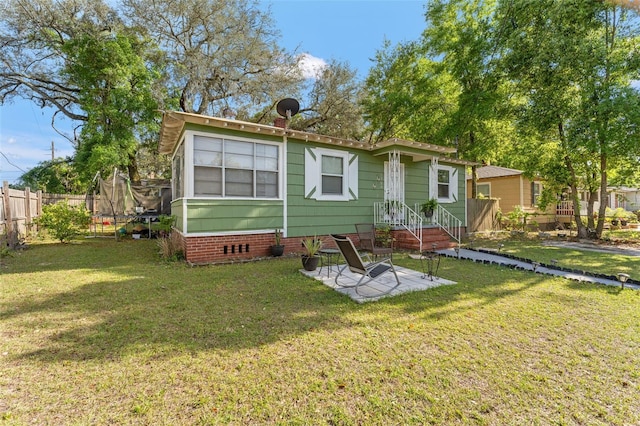1204 N Shore Dr, Jacksonville, FL 32208 - rear view of property with crawl space, a trampoline, fence, and a lawn