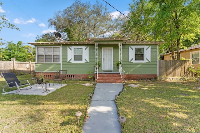 1204 N Shore Dr, Jacksonville, FL 32208 - view of front facade with a patio area, a front yard, and fence