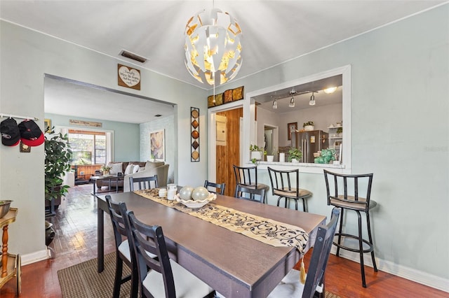 1204 N Shore Dr, Jacksonville, FL 32208 - dining room with an inviting chandelier, baseboards, visible vents, and hardwood / wood-style flooring