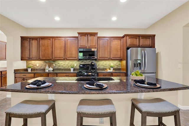 kitchen with stainless steel appliances, a kitchen breakfast bar, a sink, and decorative backsplash