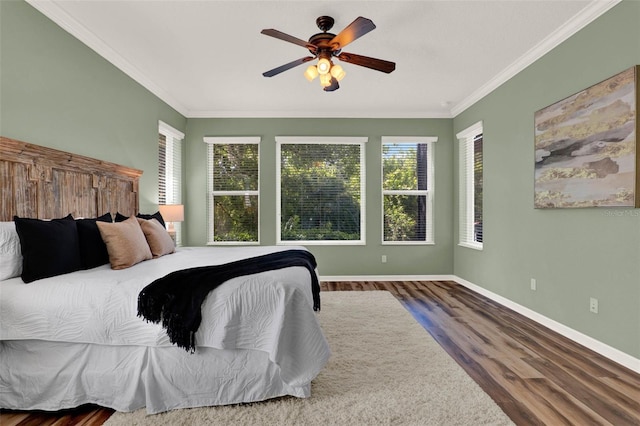 bedroom featuring ornamental molding, baseboards, ceiling fan, and wood finished floors