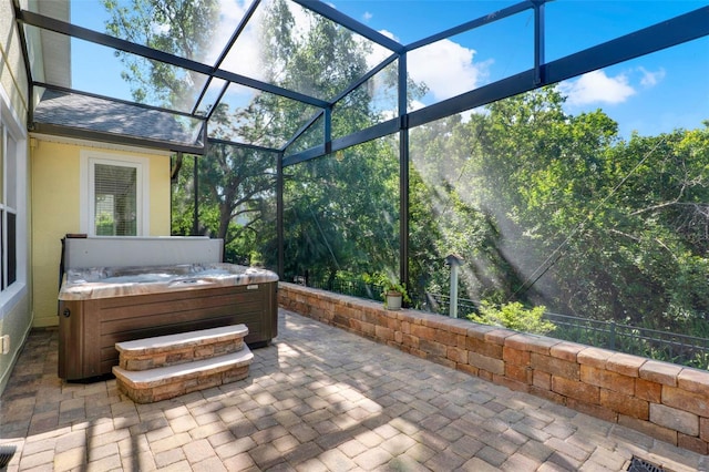 view of patio featuring a lanai and a hot tub