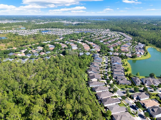aerial view featuring a water view, a view of trees, and a residential view