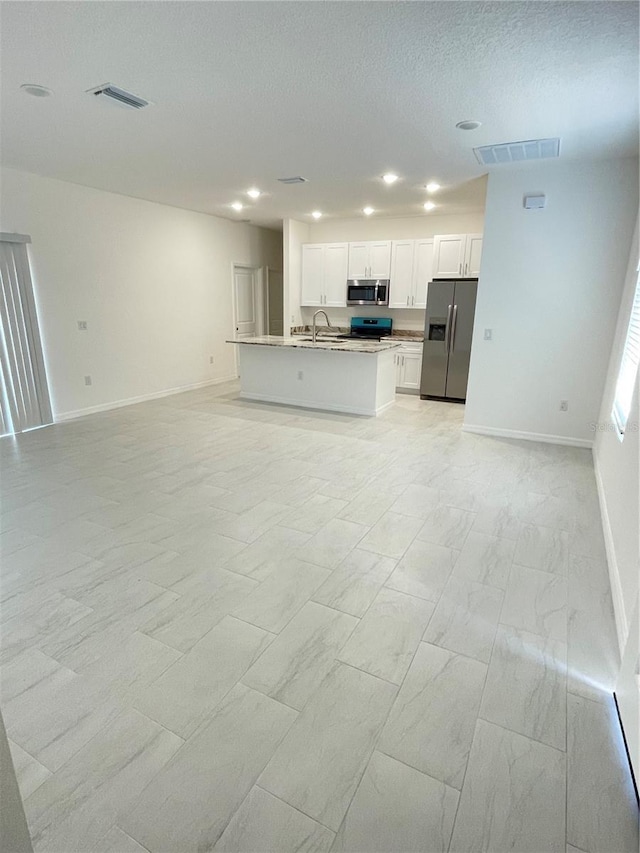 unfurnished living room featuring marble finish floor, baseboards, a sink, and visible vents