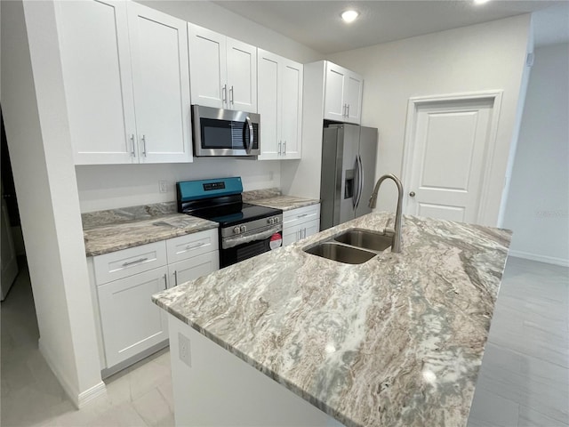 kitchen with white cabinets, a sink, a center island with sink, baseboards, and appliances with stainless steel finishes