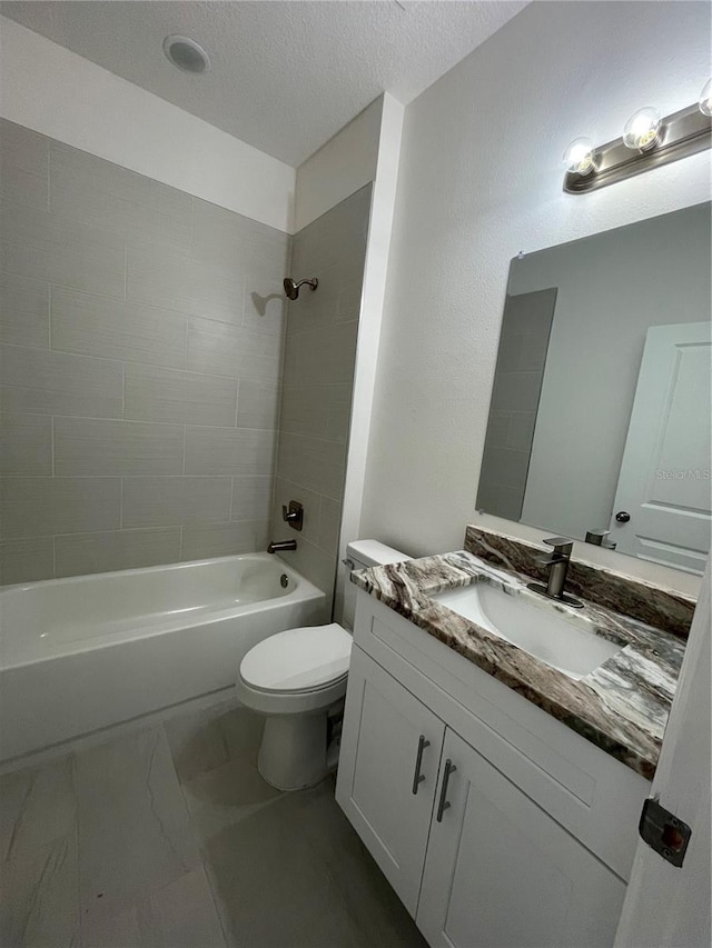full bath with marble finish floor, toilet, vanity,  shower combination, and a textured ceiling