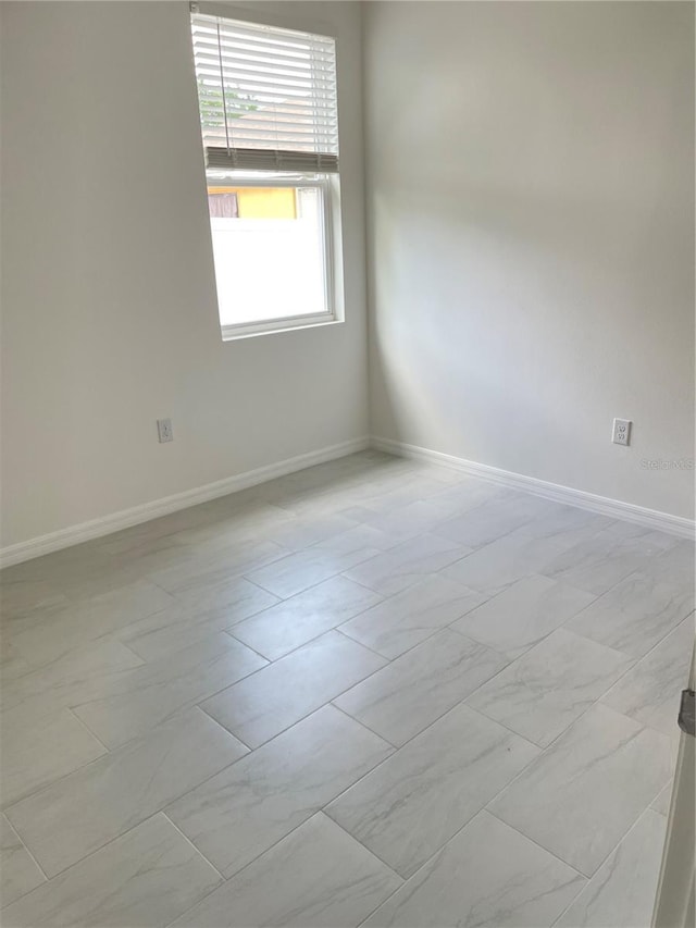 spare room featuring baseboards