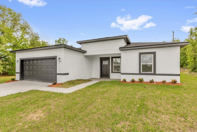 prairie-style home with concrete driveway, a front yard, stucco siding, and an attached garage